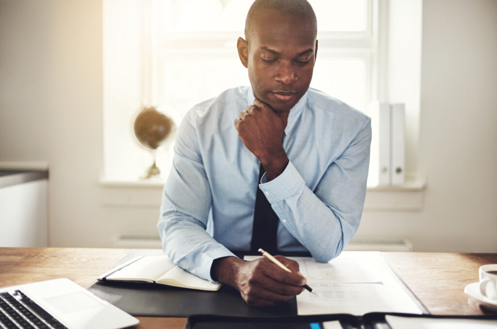 Young executive reading through paperwork at his desk